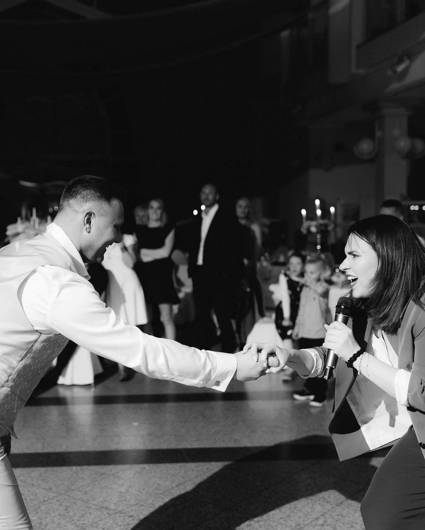 Hochzeitsmoderatorin Julia unterstützt den Bräutigam bei einer Aufgabe der Brautschuhversteigerung als Tamada auf einer deutsch russischen Hochzeit