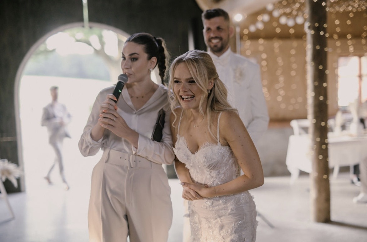 Hochzeitsmoderatorin Julia zusammen mit einer Braut und dem Bräutigam während der Moderation auf einer deutsch russischen Hochzeit